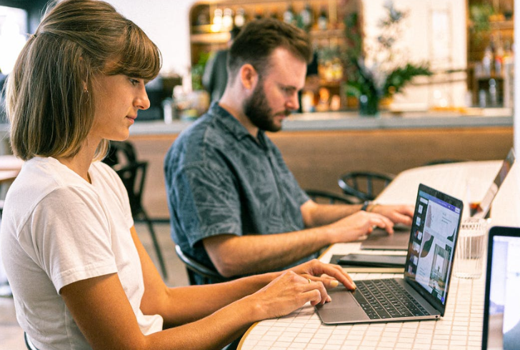 A freelancer working with a laptop in a vibrant coworking space.